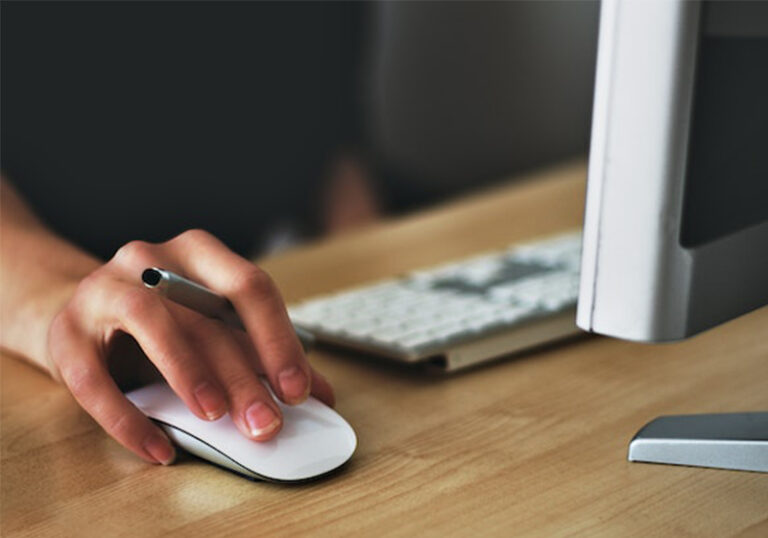 girl on the computer with her hand on a computer mouse