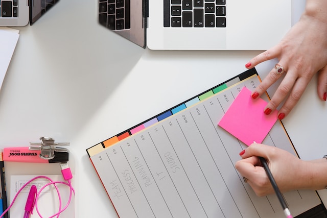 girl holding pen with a planner making notes